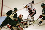 CHICAGO - OCTOBER 26: Niklas Backstrom #32 of the Minnesota Wild falls to knock the puck away from Patrick Sharp #10 of the Chicago Blackhawks as Brent Burns #8 and Nick Schultz #55 defend at the United Center on October 26, 2009 in Chicago, Illinois. The Blackhawks defeated the Wild 3-1. (Photo by Jonathan Daniel/Getty Images)
