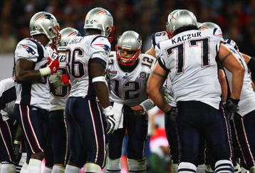 LONDON, ENGLAND - OCTOBER 25:  Tom Brady (#12) of the New England Patriots discusses tactics with his team mates during the NFL International Series match between New England Patriots and Tampa Bay Buccaneers at Wembley Stadium on October 25, 2009 in London, England. This is the third occasion where a regular season NFL match has been played in London.  (Photo by Julian Finney/Getty Images)