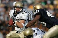 SOUTH BEND, IN - NOVEMBER 12:  Marco Nelson #29 of the Navy Midshipman runs for yardage as teammate Reggie Campbell #7 blocks Maurice Crum #40 of the Notre Dame Fighting Irish on November 12, 2005 at Notre Dame Stadium in South Bend, Indiana. Notre Dame defeated Navy 42-21.  (Photo by Jonathan Daniel/Getty Images)