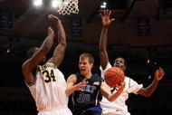NEW YORK - NOVEMBER 21: Jon Scheyer #30 of the Duke Blue Devils goes to the basket between DeShawn Sims #34 and Manny Harris #3 of the Michigan Wolverines on November 21, 2008 at Madison Square Garden in New York City. (Photo by Nick Laham/Getty Images)