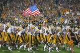 MIAMI - JANUARY 2:  The Iowa Hawkeyes take the field against USC as a team member holds the United States flag before the FedEx Orange Bowl on January 2, 2003 at Pro Player Stadium in Miami, Florida.  USC defeated Iowa 38-17.  (Photo by Eliot J. Schechter/Getty Images)