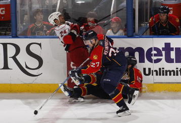SUNRISE, FL - NOVEMBER 4: Steven Reinprecht #27 skates away with the puck as Nathan Horton #16 of the Florida Panthers checks Scott Walker #24 of the Carolina Hurricanes in the third period on November 4, 2009 at the BankAtlantic Center in Sunrise, Florida. The Panthers defeated the Hurricanes 3-0. (Photo by Joel Auerbach/Getty Images)