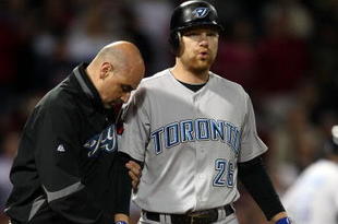 BOSTON - SEPTEMBER 29: Adam Lind #26 of the Toronto Blue Jays is looked after by a member of the medical staff after he was hit by a pitch in the ninth inning against the Boston Red Sox on September 29, 2009 at Fenway Park in Boston, Massachusetts. The Blue Jays defeated the Red Sox 8-7. (Photo by Elsa/Getty Images)