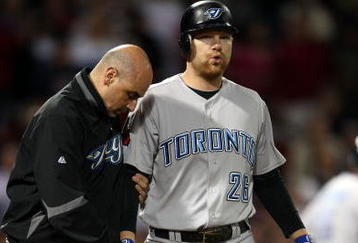 BOSTON - SEPTEMBER 29:  Adam Lind #26 of the Toronto Blue Jays is looked after by a member of the medical staff after he was hit by a pitch in the ninth inning against the Boston Red Sox on September 29, 2009 at Fenway Park in Boston, Massachusetts. The Blue Jays defeated the Red Sox 8-7.  (Photo by Elsa/Getty Images)