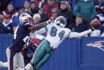22 Dec 2001 : Chris Chambers #84 of the Miami Dolphins dives to catch a pass under pressure from Ty Law #24 of the New England Patriots during the game at Foxboro Stadium in Foxboro, Massachusetts. The Patriots defeated the Dolphins 20-13. DIGITAL IMAGE. Mandatory Credit: Ezra Shaw/Getty Images