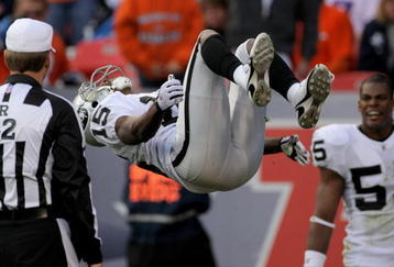 DENVER - NOVEMBER 23:  Johnnie Lee Higgins #15 of the Oakland Raiders celebrates with a back flip in front of referee Jeff Triplette after his 89 yard punt return for a second quarter touchdown against the Denver Broncos during week 12 NFL action at Invesco Field at Mile High on November 23, 2008 in Denver, Colorado. The beckflip earned a 15 yard penalty as the Raiders defeated the Broncos 31-10.  (Photo by Doug Pensinger/Getty Images)