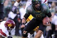 EUGENE, OR - OCTOBER 31: Quarterback Jeremiah Masoli #8 of the Oregon Ducks breaks a tackle of linebacker Malcolm Smith #6 as he heads to the end zone in the first quarter of the game against the USC Trojans at Autzen Stadium on October 31, 2009 in Eugene, Oregon. Masoli threw for 222 yards and a touchdown and ran for 164 more yards with another score as Oregon defeated USC 47-20. (Photo by Steve Dykes/Getty Images)