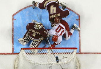 MILWAUKEE, WISCONSIN - APRIL 08:   Robbie Earl #10 of Wisconsin gets the puck past Cory Schneider #1 of Boston College as teammate Mike Brennan #4 looks on during the NCAA Men's Frozen Four Championship game on April 8, 2006 at the Bradley Center in Milwaukee, Wisconsin. The Wisconsin Badgers defeated the Boston College Eagles 2-1 to win the national title.  (Photo by Elsa/Getty Images)