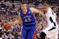 INDIANAPOLIS - MARCH 27: Cole Aldrich #45 of the Kansas Jayhawks drives against Goran Suton #14 of the Michigan State Spartans during the third round of the NCAA Division I Men's Basketball Tournament at the Lucas Oil Stadium on March 27, 2009 in Indianapolis, Indiana. (Photo by Andy Lyons/Getty Images)