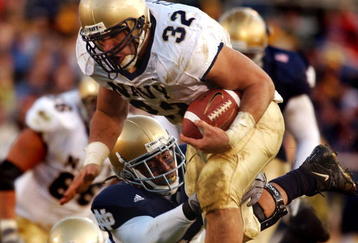 SOUTH BEND, IN - NOVEMBER 8:  In this U.S. Navy handout photo, Navy fullback Kyle Eckel evades a Notre Dame defender to gain yardage during the Navy's Midshipmen's 27-24 loss to the Fighting Irish November 8, 2003 in South Bend, Indiana.  (Photo by Scott Allen/U.S. Navy via Getty Images)