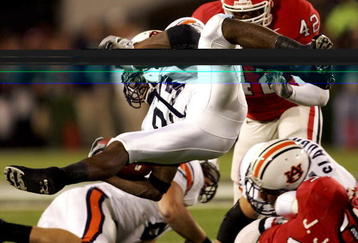 ATHENS, GA - NOVEMBER 12:  Kenny Irons #23 of the Auburn Tigers is knocked sideways as he runs with the balll against the Georgia Bulldogs during their game on November 12, 2005 at Sanford Stadium in Athens, Georgia.  (Photo by Streeter Lecka/Getty Images)