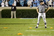 CHAPEL HILL, NC - NOVEMBER 07:  A referee stands in the middle of four penalty flags that were all thrown on the same play during a rivalry game between the Duke Blue Devils and North Carolina Tar Heels at Kenan Stadium on November 7, 2009 in Chapel Hill, North Carolina.  (Photo by Streeter Lecka/Getty Images)