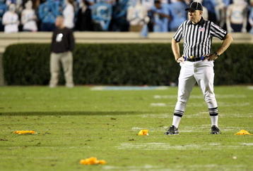 CHAPEL HILL, NC - NOVEMBER 07:  A referee stands in the middle of four penalty flags that were all thrown on the same play during a rivalry game between the Duke Blue Devils and North Carolina Tar Heels at Kenan Stadium on November 7, 2009 in Chapel Hill, North Carolina.  (Photo by Streeter Lecka/Getty Images)