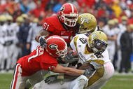 ATHENS, GA - NOVEMBER 29:  Defensive teammates Chad Gloer #17 and Akeem Dent #51 of the Georgia Bulldogs tackle running back Roddy Jones #20 of the Georgia Tech Yellow Jackets while Jones' teammate Marcus Wright #3 tries to block during the game at Sanford Stadium on November 29, 2008 in Athens, Georgia.  The Yellow Jackets defeated the Bulldogs 45-42.  (Photo by Mike Zarrilli/Getty Images)