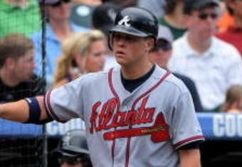 DENVER - JULY 12:  Brooks Conrad #26 of the Atlanta Braves is welcomed back to the dugout by starting pitcher Kris Medlen #54 after Conrad's two run homerun against the Colorado Rockies in the fifth inning during MLB action at Coors Field on July 12, 2009 in Denver, Colorado.  (Photo by Doug Pensinger/Getty Images)
