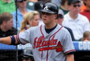 DENVER - JULY 12:  Brooks Conrad #26 of the Atlanta Braves is welcomed back to the dugout by starting pitcher Kris Medlen #54 after Conrad's two run homerun against the Colorado Rockies in the fifth inning during MLB action at Coors Field on July 12, 2009 in Denver, Colorado.  (Photo by Doug Pensinger/Getty Images)