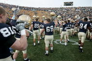 SOUTH BEND, IN - NOVEMBER 12:  Members of the Notre Dame Fighting Irish inclduing Rob Woods #81, Neil Kennedy #69 and Justin Brown #94 salute the students and fans following a game against the Navy Midshipman on November 12, 2005 at Notre Dame Stadium in South Bend, Indiana. Notre Dame defeated Navy 42-21. (Photo by Jonathan Daniel/Getty Images)