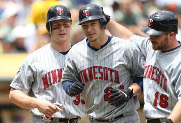 OAKLAND, CA - JUNE 11:  Joe Crede #24 of the Minnesota Twins is congratulated by Jason Kubel #16 and Justin Morneau #33 after hitting a home run in the fourth inning against the Oakland Athletics during a Major League Baseball game on June 11, 2009 at the Oakland Coliseum in Oakland, California.  (Photo by Jed Jacobsohn/Getty Images)