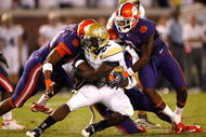 ATLANTA - SEPTEMBER 10:  Running back Jonathan Dwyer #21 of the Georgia Tech Yellow Jackets rushes upfield against Scotty Cooper #44, Andre Branch #40 and DeAndre McDaniel #2 of the Clemson Tigers at Bobby Dodd Stadium on September 10, 2009 in Atlanta, Georgia.  (Photo by Kevin C. Cox/Getty Images)
