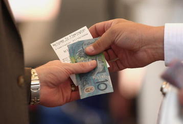 MELBOURNE, AUSTRALIA - OCTOBER 31:  A bookietakes a bet during the 2009 Victoria Derby Day meeting at Flemington Racecourse on October 31, 2009 in Melbourne, Australia.  (Photo by Quinn Rooney/Getty Images)