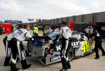 FORT WORTH, TX - NOVEMBER 08:  Crew members push the #48 Lowe's Chevrolet into the garage after being involved in an incident on the track during the NASCAR Sprint Cup Series Dickies 500 at Texas Motor Speedway on November 8, 2009 in Fort Worth, Texas.  (Photo by Geoff Burke/Getty Images for NASCAR)
