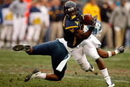 CHARLOTTE, NC - DECEMBER 27:  Trimane Goddard #31 of the North Carolina Tar Heels misses a tackle on Jock Sanders #9 of the West Virginia Mountaineers during the Meineke Car Care Bowl on December 27, 2008 at Bank of America Stadium in Charlotte, North Carolina.  (Photo by Streeter Lecka/Getty Images)