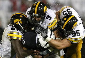 STATE COLLEGE, PA - SEPTEMBER 26:  Evan Royster #22 of the Penn State Nittnay Lions is tackled by Karl Klug #95, Tyler Sash #9, and Broderick Binns #91 of the Iowa Hawkeye's on September 26, 2009 at Beaver Stadium in State College, Pennsylvania. Iowa won the game 21-10 (Photo by Gregory Shamus/Getty Images)