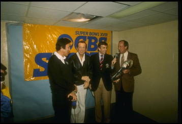 22 Jan 1984: Los Angeles Raiders head coach Tom Flores, Raiders owner Al Davis, Brent Musberger, and NFL Commissioner Pete Rozelle (l to r) at the presentation of the Lombardi Trophy after Super Bowl XVIII between the Los Angeles Raiders and the Washingto