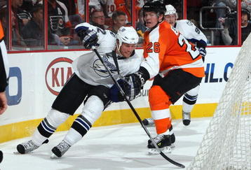 PHILADELPHIA - NOVEMBER 02:  Ryan Malone #12 of the Tampa Bay Lightning skates against Danny Syvret #26 of the Philadelphia Flyers on November 2, 2009 at Wachovia Center in Philadelphia, Pennsylvania. The Flyers won the game 6-2.  (Photo by Jim McIsaac/Getty Images)