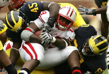 ANN ARBOR, MI - SEPTEMBER 23:  David Harris #45 and Alan Branch #80 of the Michigan Wolverines stop P.J. Hill #39 of the Wisconsin Badgers on September 23, 2006 at Michigan Stadium in Ann Arbor, Michigan. Michigan defeated Wisconsin 27-13.  (Photo by Jonathan Daniel/Getty Images)