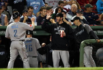 BOSTON - SEPTEMBER 29:  Aaron Hill #2 and Adam Lind #26 of the Toronto Blue Jays are congratulated by teammates after Lind hit a two run homer in the first inning against the Boston Red Sox on September 29, 2009 at Fenway Park in Boston, Massachusetts.  (Photo by Elsa/Getty Images)