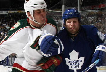 TORONTO, ON - NOVEMBER 10: Colton Orr #28 of the Toronto Maple Leafs is hit by Derek Boogaard #24 of the Minnesota Wild at the Air Canada Centre on November 10, 2009 in Toronto, Canada. (Photo by Bruce Bennett/Getty Images)