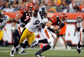 CINCINNATI - SEPTEMBER 27:  Carson Palmer #9 of the Cincinnati Bengals runs with the ball while defended by James Harrison #92 of the Pittsburgh Steelers at Paul Brown Stadium on September 27, 2009 in Cincinnati, Ohio.  The Bengals won 23-20.  (Photo by Andy Lyons/Getty Images)