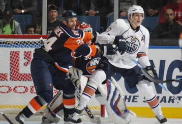 UNIONDALE, NY - NOVEMBER 02: Shawn Horcoff #10 of the Edmonton Oilers is moved out of the crease by Radek Martinek #24 of the New York Islanders at the Nassau Coliseum on November 2, 2009 in Uniondale, New York. (Photo by Bruce Bennett/Getty Images)