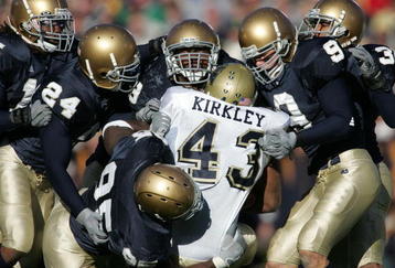 SOUTH BEND, IN - NOVEMBER 13:  Defensive members of Notre Dame including end Victor Abiamiri #95, cornerback Dwight Ellick #24, safety Tom Zbikowski #9 and linebacker Derek Curry #49 stop tailback Raymond Kirkley #43 of Pittsburgh on November 13, 2004 at Notre Dame Stadium in South Bend, Indiana.  (Photo by Jonathan Daniel/Getty Images)