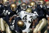 SOUTH BEND, IN - NOVEMBER 13:  Defensive members of Notre Dame including end Victor Abiamiri #95, cornerback Dwight Ellick #24, safety Tom Zbikowski #9 and linebacker Derek Curry #49 stop tailback Raymond Kirkley #43 of Pittsburgh on November 13, 2004 at Notre Dame Stadium in South Bend, Indiana.  (Photo by Jonathan Daniel/Getty Images)