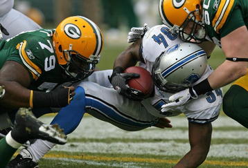 GREEN BAY, WI - OCTOBER 18: Kevin Smith #34 of the Detroit Lions is tackled by Ryan Pickett #79 and A.J. Hawk #50 of the Green Bay Packers at Lambeau Field on October 18, 2009 in Green Bay, Wisconsin. The Packers defeated the Lions 26-0. (Photo by Jonathan Daniel/Getty Images)