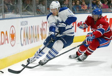TORONTO - OCTOBER 1:  Luke Schenn #2 of the Toronto Maple Leafs clears the puck away from Maxim Lapierre #40 of the Montreal Canadiens in the Maple Leafs home opener on October 1, 2009 at the Air Canada Centre in Toronto, Ontario, Canada.  (Photo by Claus Andersen/Getty Images)