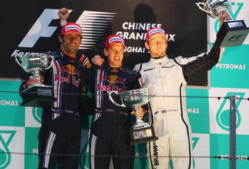 SHANGHAI, CHINA - APRIL 19:  Race winner Sebastian Vettel (C) of Germany and Red Bull Racing celebrates with second placed team mate Mark Webber (L) of Australia and Red Bull Racing and third placed Jenson Button (R) of Great Britain and Brawn GP on the podium after the Chinese Formula One Grand Prix at the Shanghai International Circuit on April 19, 2009 in Shanghai, China.  (Photo by Mark Thompson/Getty Images)