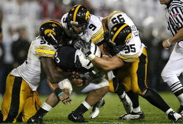 STATE COLLEGE, PA - SEPTEMBER 26:  Evan Royster #22 of the Penn State Nittnay Lions is tackled by Karl Klug #95, Tyler Sash #9, and Broderick Binns #91 of the Iowa Hawkeye's on September 26, 2009 at Beaver Stadium in State College, Pennsylvania. Iowa won the game 21-10 (Photo by Gregory Shamus/Getty Images)