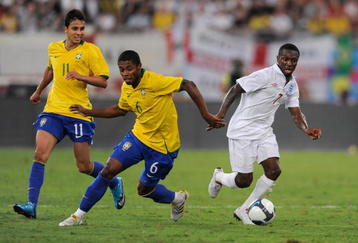 DOHA, QATAR - NOVEMBER 14: Shaun Wright-Phillips of England takes on Nilmar Honorato Da Silva and Michel Fernandes Bastos during the International Friendly match between Brazil and England at the Khalifa Stadium on November 14, 2009 in Doha, Qatar.  (Photo by Michael Regan/Getty Images)