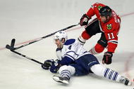 CHICAGO - NOVEMBER 13: John Madden #11 of the Chicago Blackhawks falls over Jeff Finer #4 of the Toronto Maple Leafs at the United Center on November 13, 2009 in Chicago, Illinois. The Blackhawks defeated the Maple Leafs 3-2. (Photo by Jonathan Daniel/Getty Images)