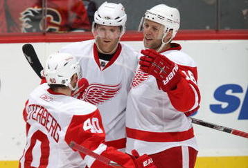 CALGARY, CANADA - OCTOBER 31: Kirk Maltby #18 of the Detroit Red Wings celebrates with teammates Daniel Cleary #18 and Henrik Zetterberg #40 during a break in game action against the Calgary Flames on October 31, 2009 at the Pengrowth Saddledome in Calgary, Alberta, Canada. The Red Wings defeated the Flames 3-1. (Photo by Dale MacMillan/Getty Images)