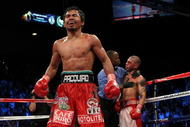 LAS VEGAS - NOVEMBER 14:  Manny Pacquiao celebrates his 12 round TKO victory against Miguel Cotto as Cotto is consoled by referee Kenny Bayless after their WBO welterweight title fight at the MGM Grand Garden Arena on November 14, 2009 in Las Vegas, Nevada.  (Photo by Al Bello/Getty Images)