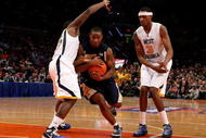 NEW YORK - MARCH 11: Tory Jackson #2 of the Notre Dame Fighting Irish drives to the hoop against Darryl Bryant #25 and Devin Ebanks #3 of the West Virginia Mountaineers during the second round of the Big East Tournament at Madison Square Garden on March 11, 2009 in New York City.  (Photo by Jim McIsaac/Getty Images)