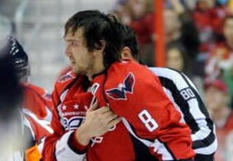 WASHINGTON - NOVEMBER 01:  Alex Ovechkin #8 of the Washington Capitals holds his shoulder as he is escorted to the penalty box after receiving a roughing penalty in the second period against the Columbus Blue Jackets at the Verizon Center on November 1, 2009 in Washington, DC.  (Photo by Greg Fiume/Getty Images)