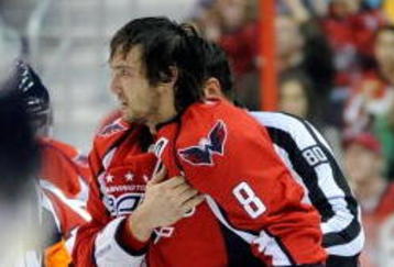 WASHINGTON - NOVEMBER 01:  Alex Ovechkin #8 of the Washington Capitals holds his shoulder as he is escorted to the penalty box after receiving a roughing penalty in the second period against the Columbus Blue Jackets at the Verizon Center on November 1, 2009 in Washington, DC.  (Photo by Greg Fiume/Getty Images)
