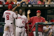 KANSAS CITY, MO - JULY 22:  Chone Figgins #9 of the Los Angeles Angels is congratulated by Vladimir Guerrero #27 and other teammates after scoring a run for the lead in the 10th inning against the Kansas City Royals on July 22, 2006 at Kauffman Stadium in Kansas City, Missouri. The Angels defeated the Royals 4-3 in 10 innings.  (Photo by Jamie Squire/Getty Images)