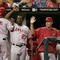KANSAS CITY, MO - JULY 22: Chone Figgins #9 of the Los Angeles Angels is congratulated by Vladimir Guerrero #27 and other teammates after scoring a run for the lead in the 10th inning against the Kansas City Royals on July 22, 2006 at Kauffman Stadium in Kansas City, Missouri. The Angels defeated the Royals 4-3 in 10 innings. (Photo by Jamie Squire/Getty Images)