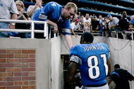 DETROIT, MI - SEPTEMBER 27:  Wide receiver Calvin Johnson #81 of the Detroit Lions celebrates with a fan as he walks off the field after the victory against the Washington Redsklns at Ford Field on September 27, 2009 in Detroit, Michigan. The Lions defeated the Redskins 19-14. (Photo by Scott Boehm/Getty Images)